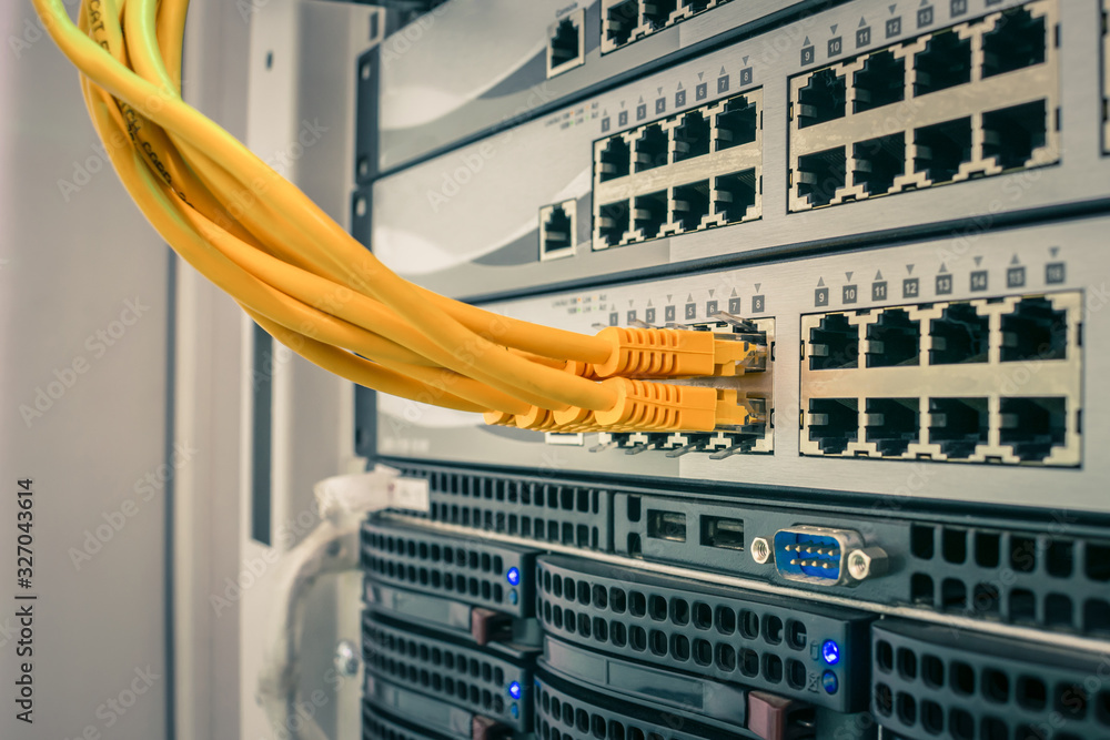 A bunch of yellow utp cables connect to the network interfaces of the  Internet router. Switching wires are connected to the server switch. The  technological concept of a modern data center. Stock
