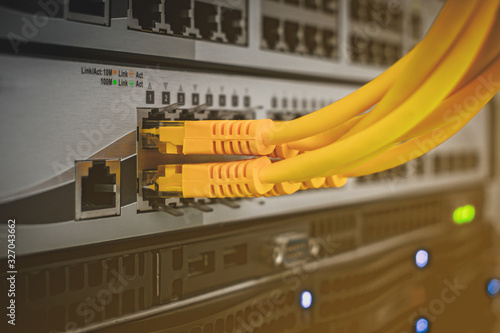 Switching wires are connected to the server switch. The technological concept of a modern data center. A bunch of yellow utp cables connect to the network interfaces of the Internet router.