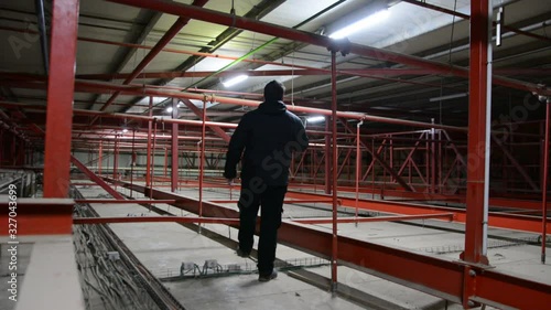 Technician check the sprinklers pipes and roof constructions. Low light, Dust moving  in air flow and light.