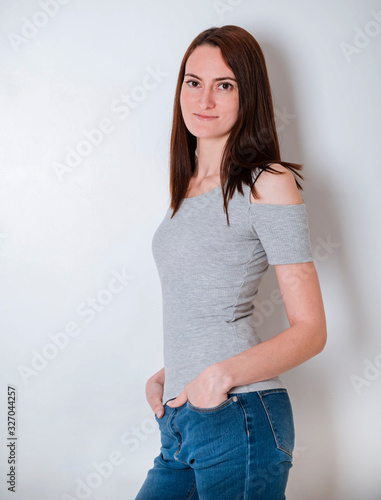 young brown haired woman in a grey top and jeans, portrait of a girl,