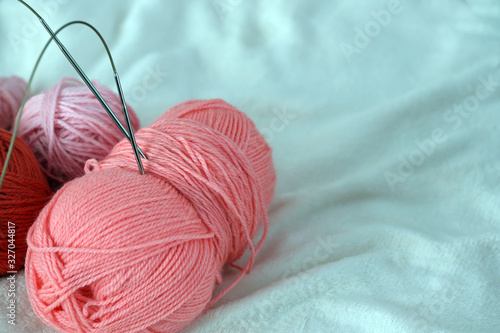  pink balls of yarn and knitting needles