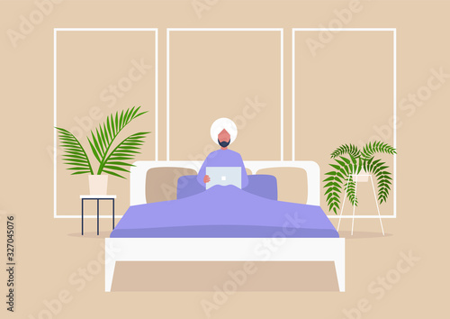 Young indian male character lying in bed with computer, bedroom interior, millennial lifestyle