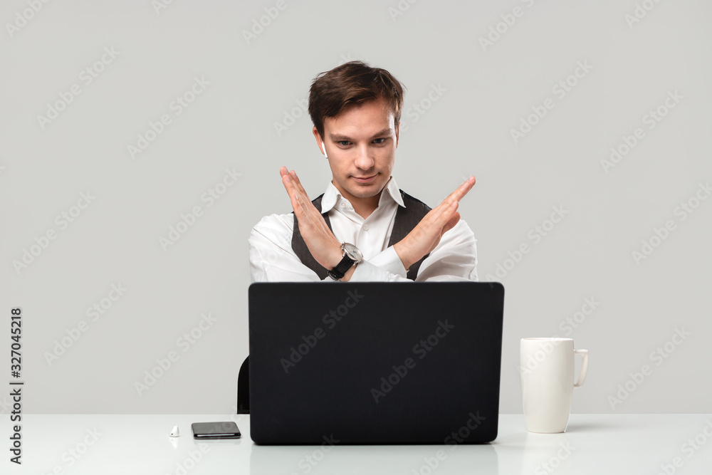 Businessman in a white t-shirt and grey vest is shocked checking information on a laptop Businessman in a white t-shirt and grey vest is shocked checking information on a laptop