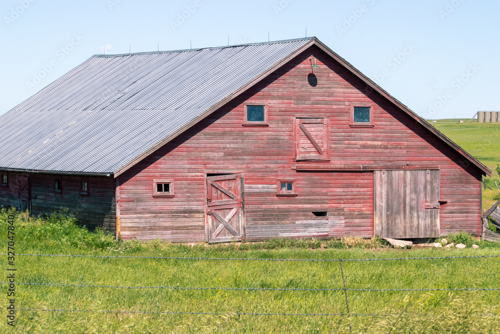 An old barn in a grassy field. High quality photo An old barn in a grassy field. High quality photo