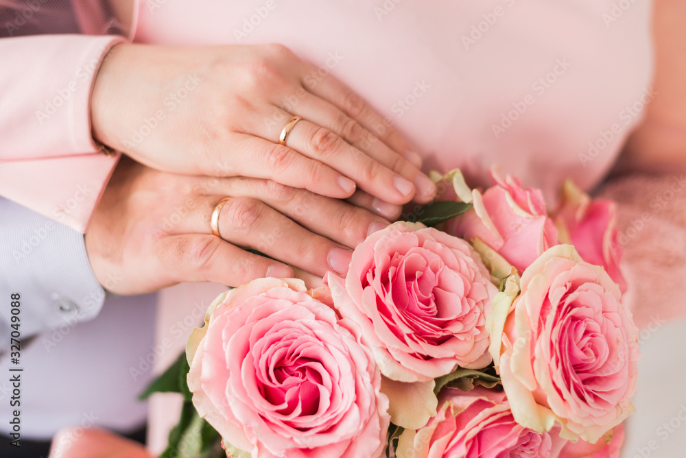 newlyweds ' hands with rings. Wedding bouquet on the background of the hands of the bride and groom with a gold ring newlyweds ' hands with rings. Wedding bouquet on the background of the hands of the bride and groom with a gold ring