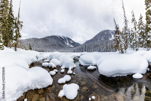 Beautiful Canadian Mountain Landscape View of White Puffy Snow Covered Joffre Lake during a vibrant winter day. Located near Pemberton  North of Vancouver  BC  Canada. Panorama