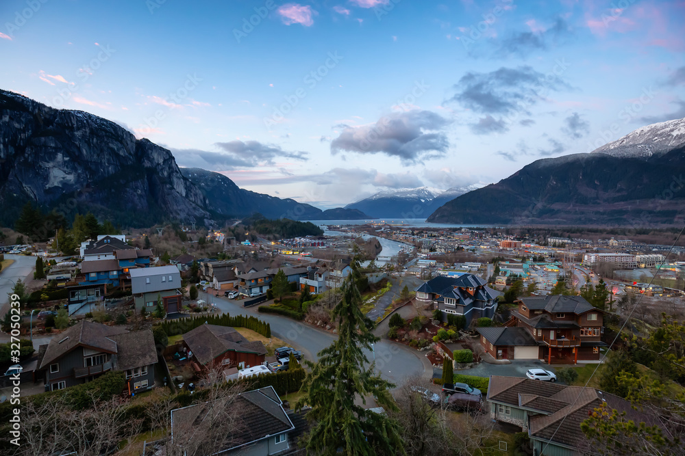Squamish, British Columbia, Canada. Aerial View of a small Outdoor town surounded by Canadian Mountains during a vibrant and colorful winter sunrise.