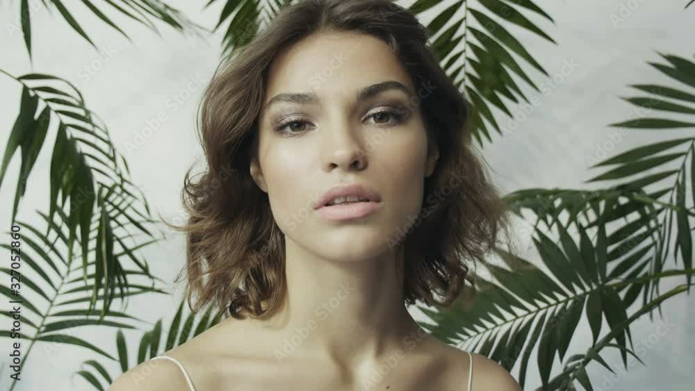 Tanned girl among tropical plants. Palm leaves. Perfect skin. Natural cosmetics. Skin care. Tanned girl among tropical plants. Palm leaves. Perfect skin. Natural cosmetics. Skin care.