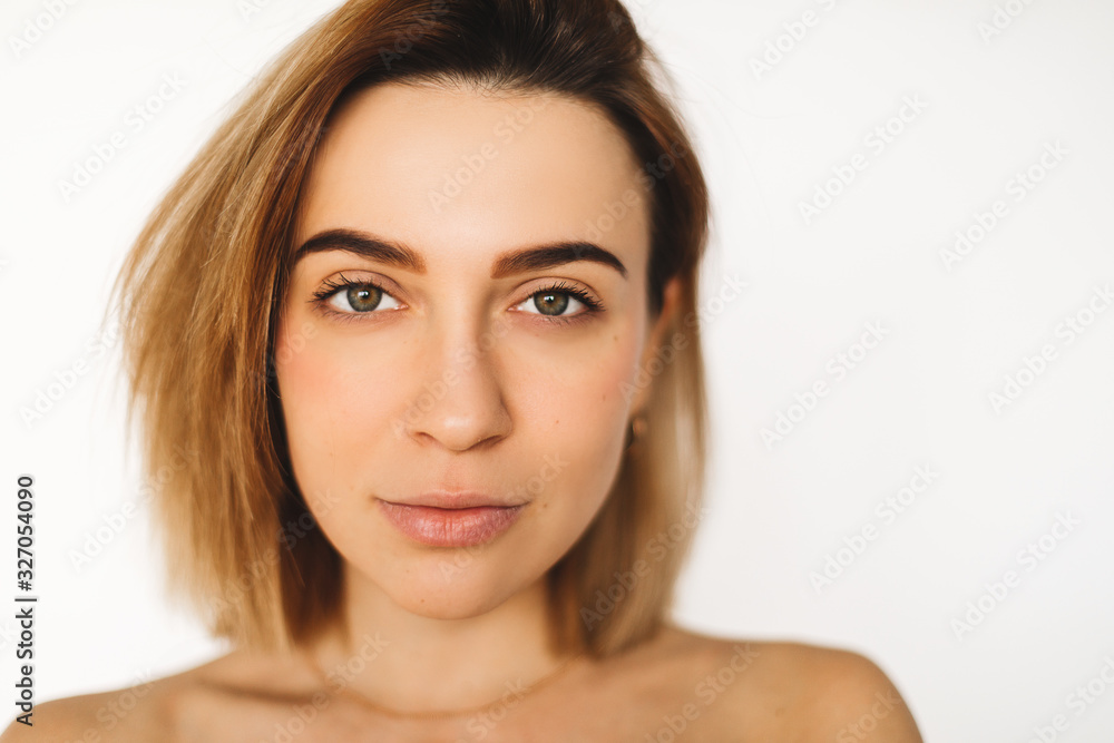 Beautiful woman face close up studio on white background. Beautiful model girl with perfect fresh clean skin. Blonde brunette short hair youth and skin care concept. Female looking at camera and smile Beautiful woman face close up studio on white background. Beautiful model girl with perfect fresh clean skin. Blonde brunette short hair youth and skin care concept. Female looking at camera and smile