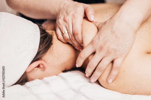 Stress relief in the massage parlor - relaxing massage of the trapezius muscle and shoulders