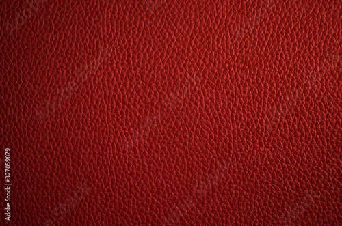 Leather texture close up. Dark red fashionable background, top view. Stylish wallpaper of snake skin. Rough surface of maroon color.