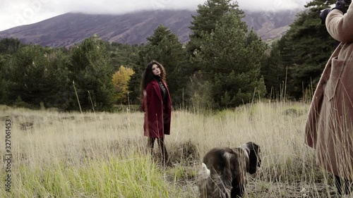 Scene from a photo shoot in the mountains, girl with a red coat posing