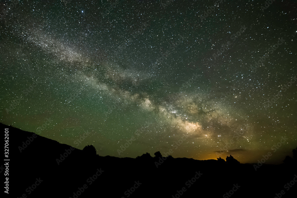 A brilliant view of the stars of the Milky Way Galaxy seen from Dark Night Skies North of Tonopah, Nevada, USA with the glow of Las Vegas on the horizon some 300 miles south.