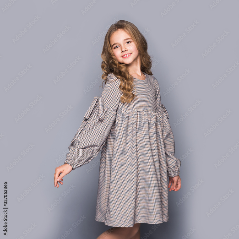 smiling schoolgirl in uniform on gray background smiling schoolgirl in uniform on gray background