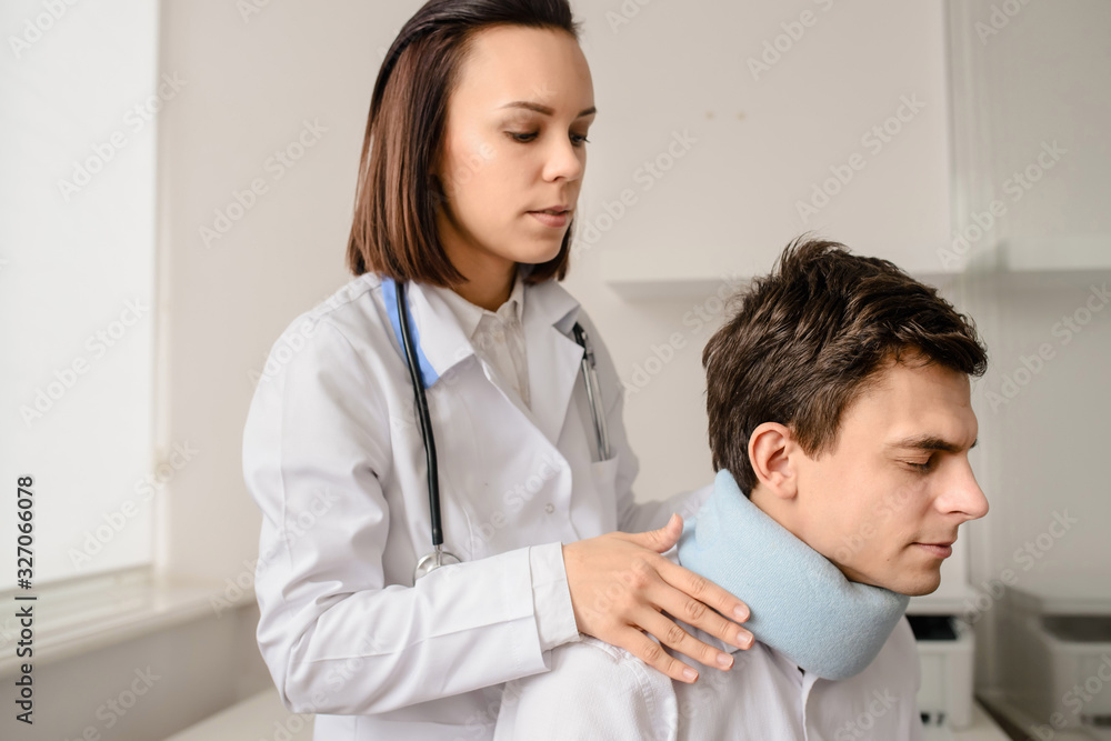 Young woman doctor apply traumatological collar Young woman doctor apply traumatological collar
