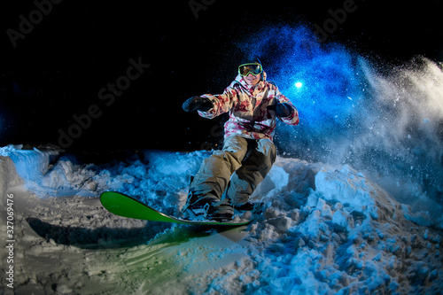 Male in winter clothes glides on a snowboard