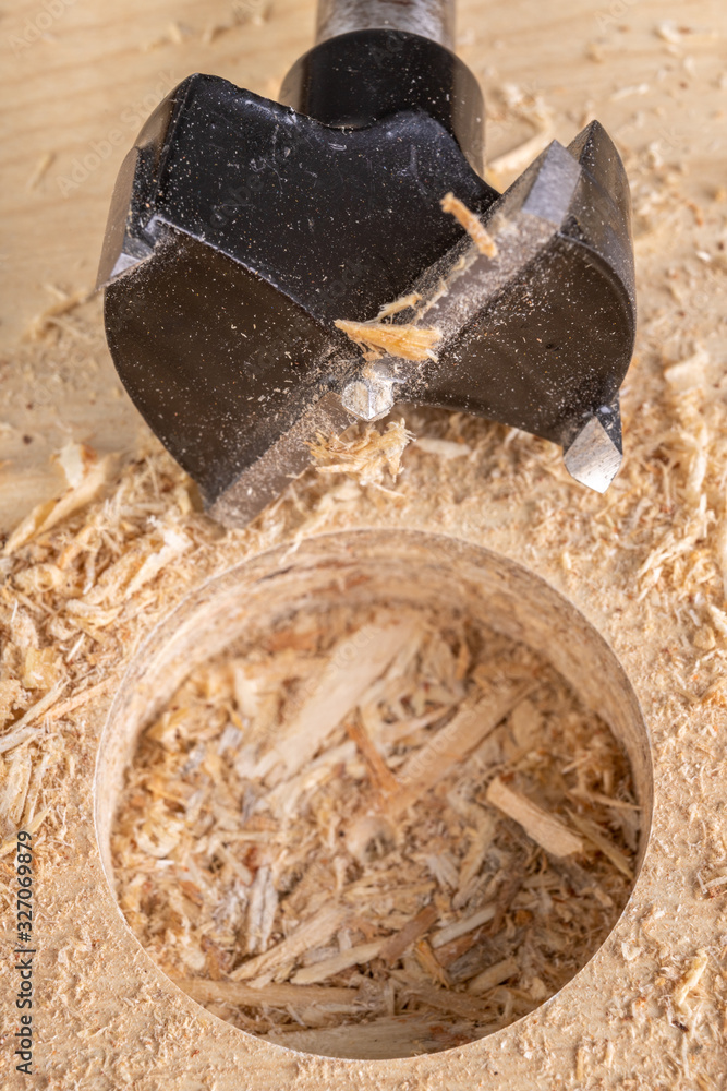 Drilling with a special drill in chipboard. Work in a carpentry workshop. Drilling with a special drill in chipboard. Work in a carpentry workshop.