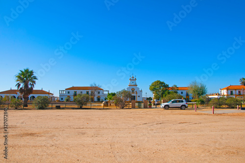 Sand square, small spanish village, white big car. Sunny spring day. Isla Mayor, Seville, Spain © Tamara