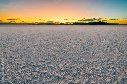 Bonneville Salt Flats colorful landscape reflection and twilight sunset near Salt Lake City  Utah and silhouette view of mountains and sun setting behind clouds