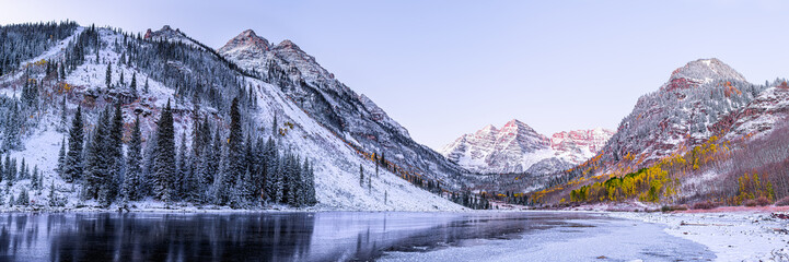 Maroon Bells morning sunrise panorama with sunlight on peak in Aspen, Colorado rocky mountain and autumn yellow foliage panoramic view winter snow