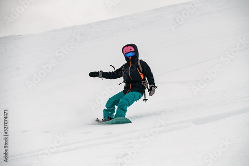 Female freerider glides down the mountain slope