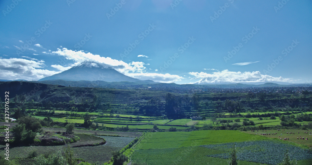 landscape photograph showing the chilina valley with crops and agricultural land with the misti volcano in the city of Arequipa in the background with clouds and blue sky. landscape photograph showing the chilina valley with crops and agricultural land with the misti volcano in the city of Arequipa in the background with clouds and blue sky.