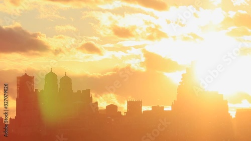 The sky glows by sunset over the Central Park West Residences. Central Park West Residences become silhouettes. Image was captured from Central park.