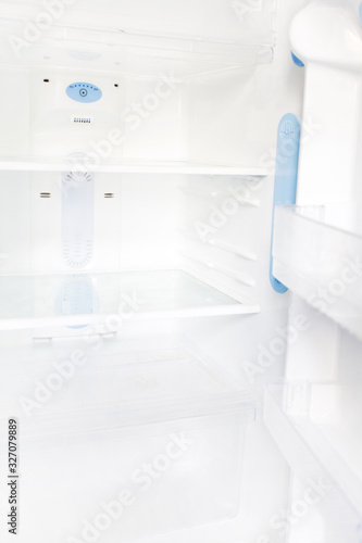 Interior of an empty open white refrigerator