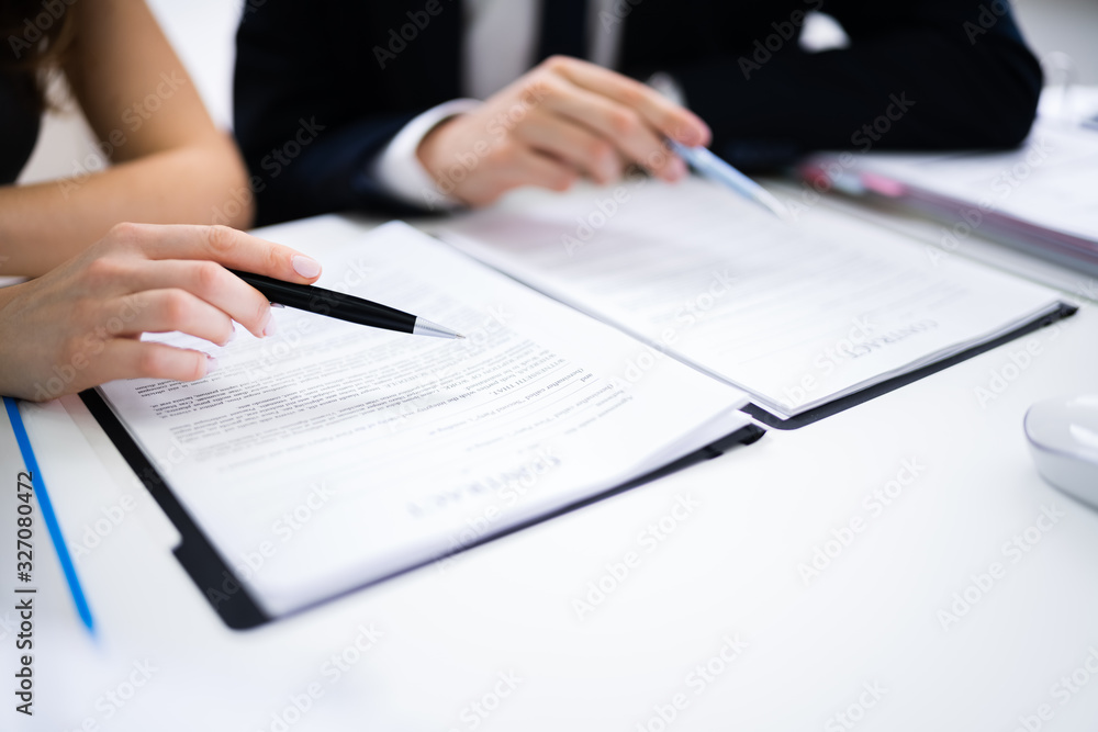 Two Businesspeople Working On Contract Paper Two Businesspeople Working On Contract Paper