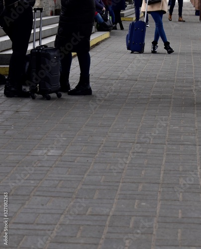 Girl waiting for the train on the station platform with a blue suitcase © Irik