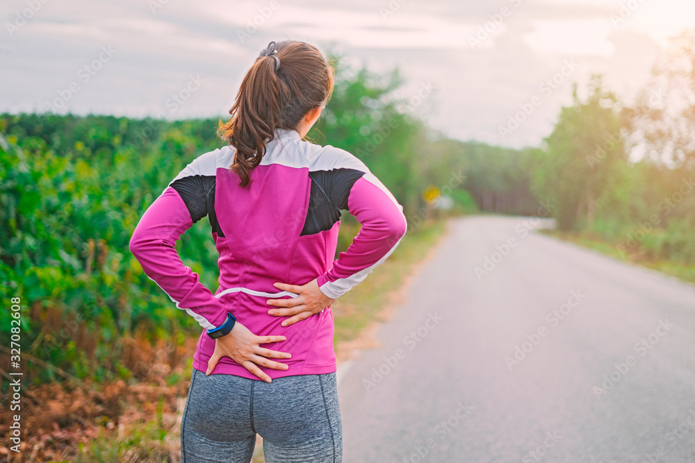 sport runner woman cramps in back and feel pain, athletic young Asian