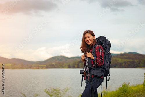 Asian woman traveler with backpack looking at amazing mountains river wanderlust and forest, Traveling tropical travel concept, copy space for text, see the beautiful natural landscape in Thailand