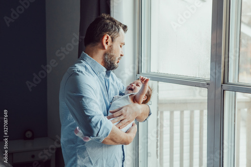 Fotografie Middle age Caucasian father trying to calm down newborn baby