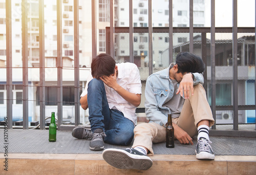 two men drung and sit on street together photo