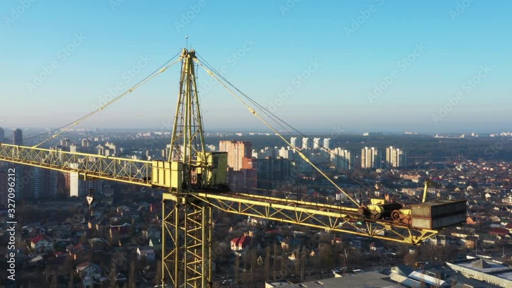 Multi-storey building, tower crane and construction site, top view. At sunset. Multi-storey building, tower crane and construction site, top view. At sunset.