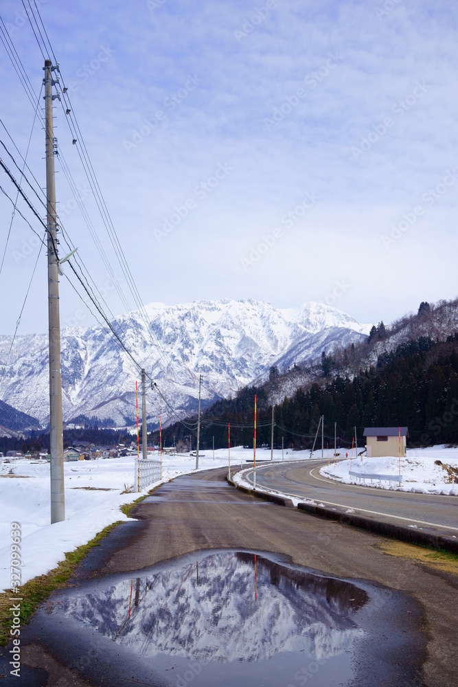 Obraz premium 霊峰を映す歩道の水たまりでのリフレクション