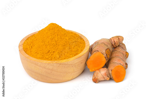 Turmeric powder in a wooden bowl and turmeric (curcumin) rhizomes isolate on a white background.