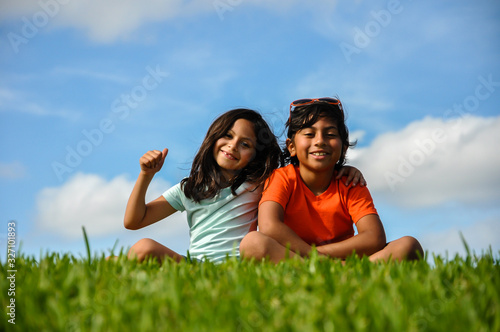 young boy girl brother sister thumbs up free education, learning, fafsa, universal income approved, sitting indian style grass learning approved