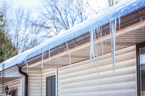 Ice dam in gutter and ice frozen on roof in winter