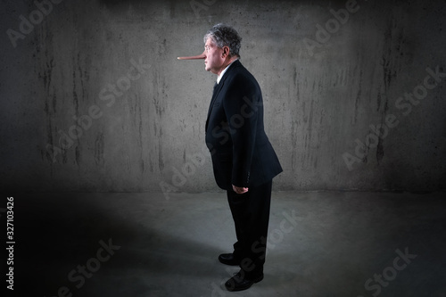 фотографія Lying businessman with a long nose standing in a suit, liar concept