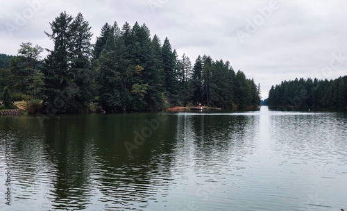 Wonderful Lacamas Lake on a breezy cloudy morning with the wilderness reflecting in the calm shimmering water in Camas Washington