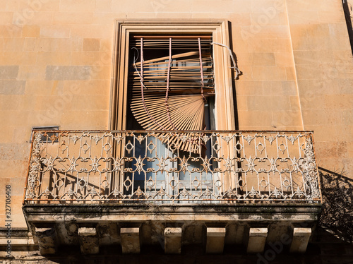 Vecchio balcone con veneziana distrutta photo