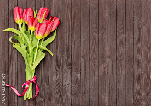 Bouquet of Red tulips on brown wooden background. Mother's Day and Valentines, March Day.