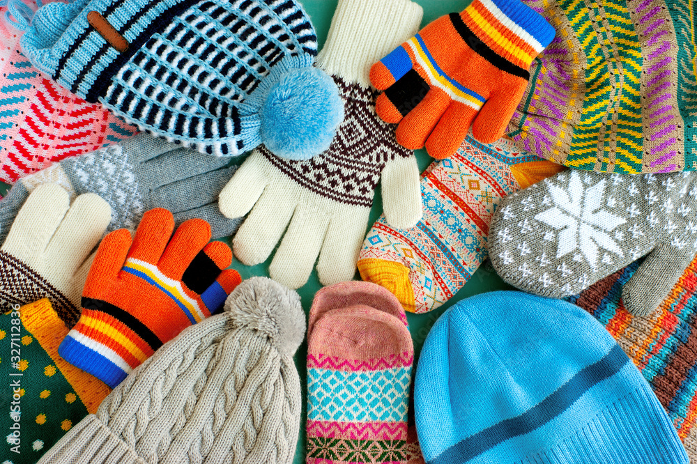 A lot of hats, gloves, mittens. Warm clothes in the form of knitted hats,  mittens, gloves, scarves for the cold seasons. Multi-colored clothes for  autumn and winter. Stock Photo