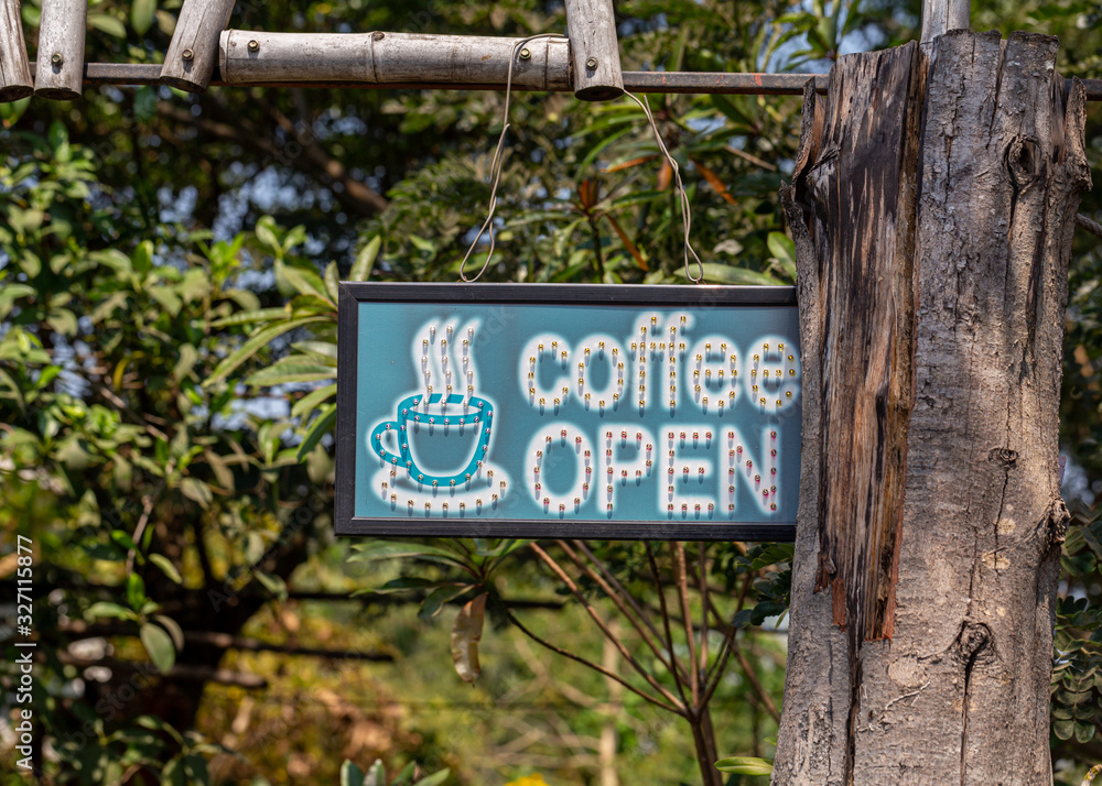Vintage coffee shop sign board hanging on wood gate
