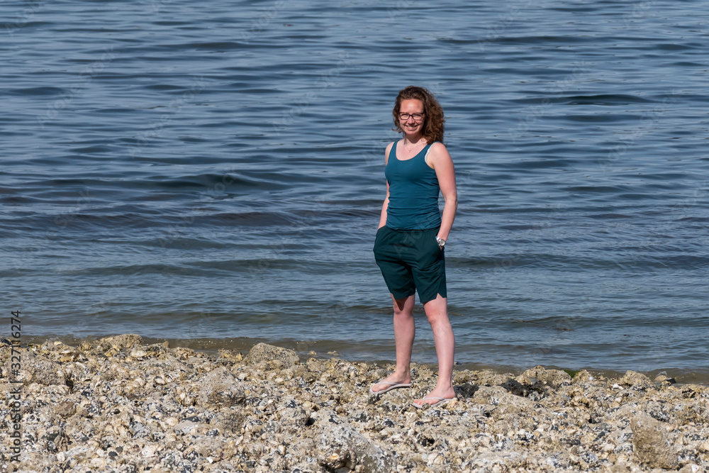 A Young woman standing on the beach, Union bay. Vancouver Island, British Columbia, Canada