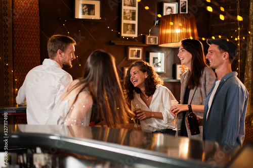 Happy group of friends at the bar having drinks. photo