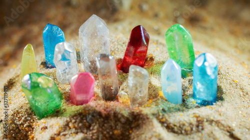 Fotografia Multicolored crystal quartz sticks of gems protrude from the sand