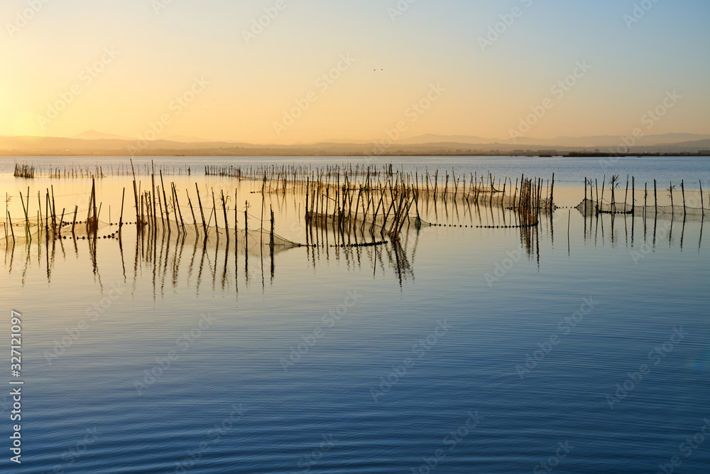the sunset with fishing nets on a lake