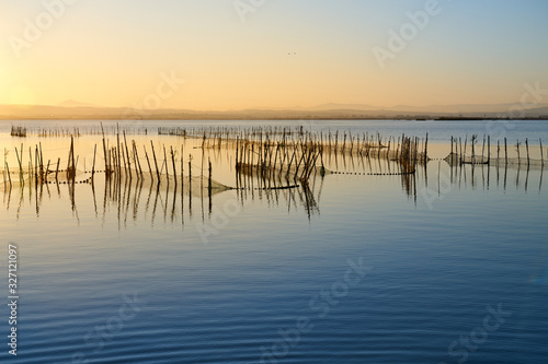the sunset with fishing nets on a lake © Photoderox